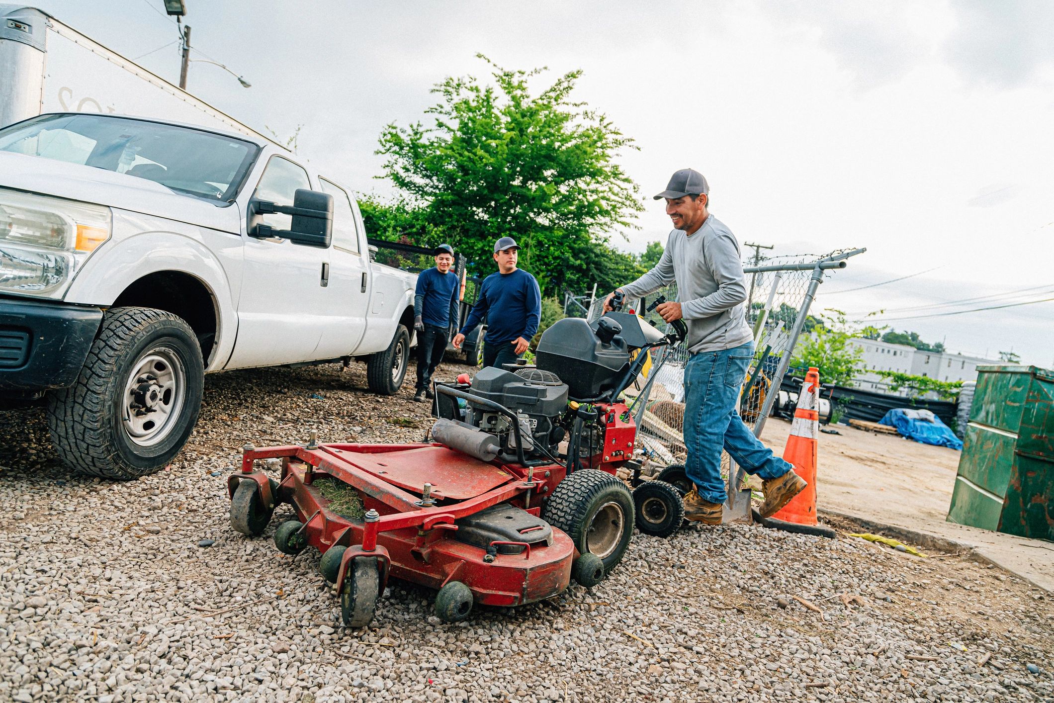 Landscaper loading a riding mower for lawn care