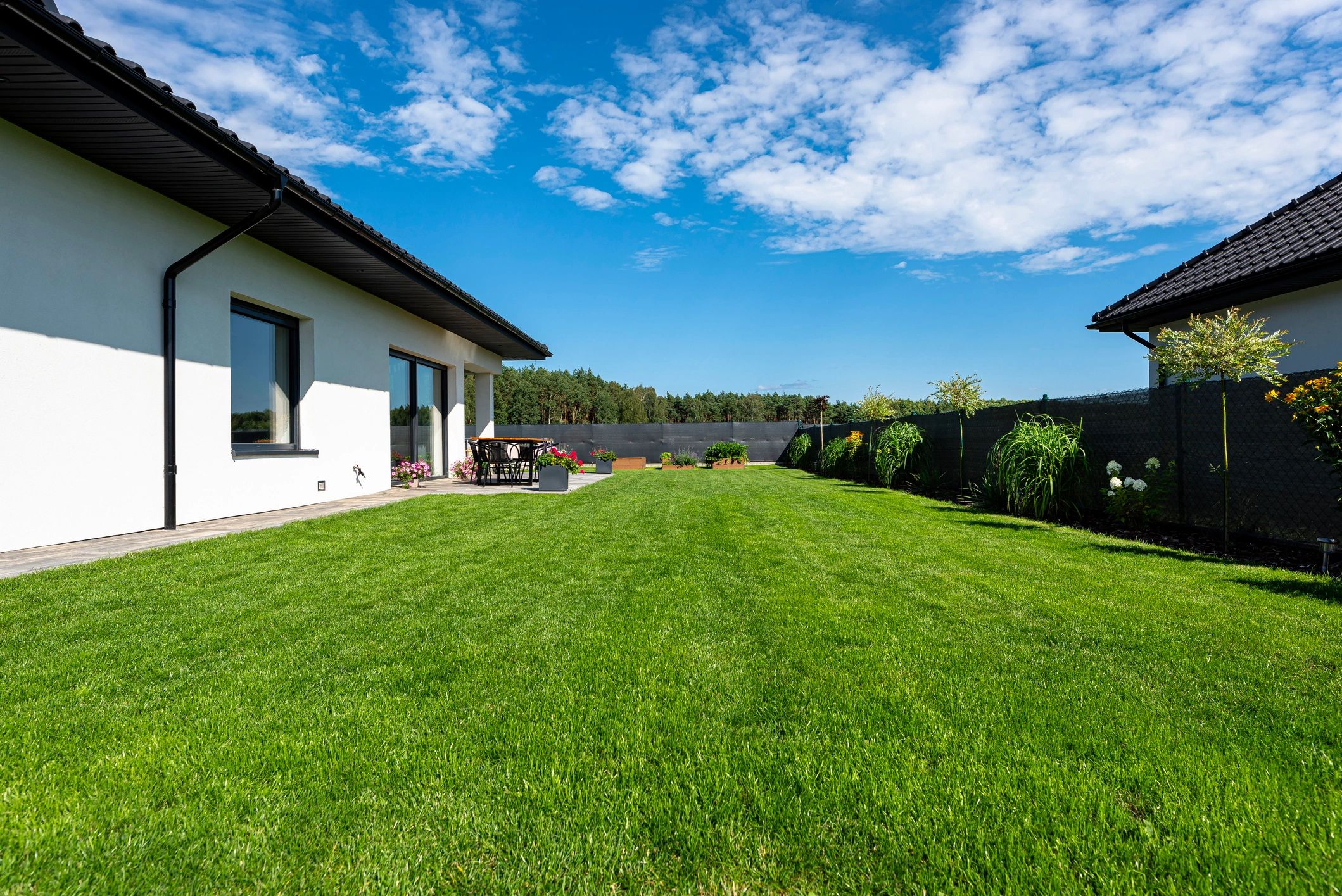 Landscaped backyard garden with patio and lush lawn